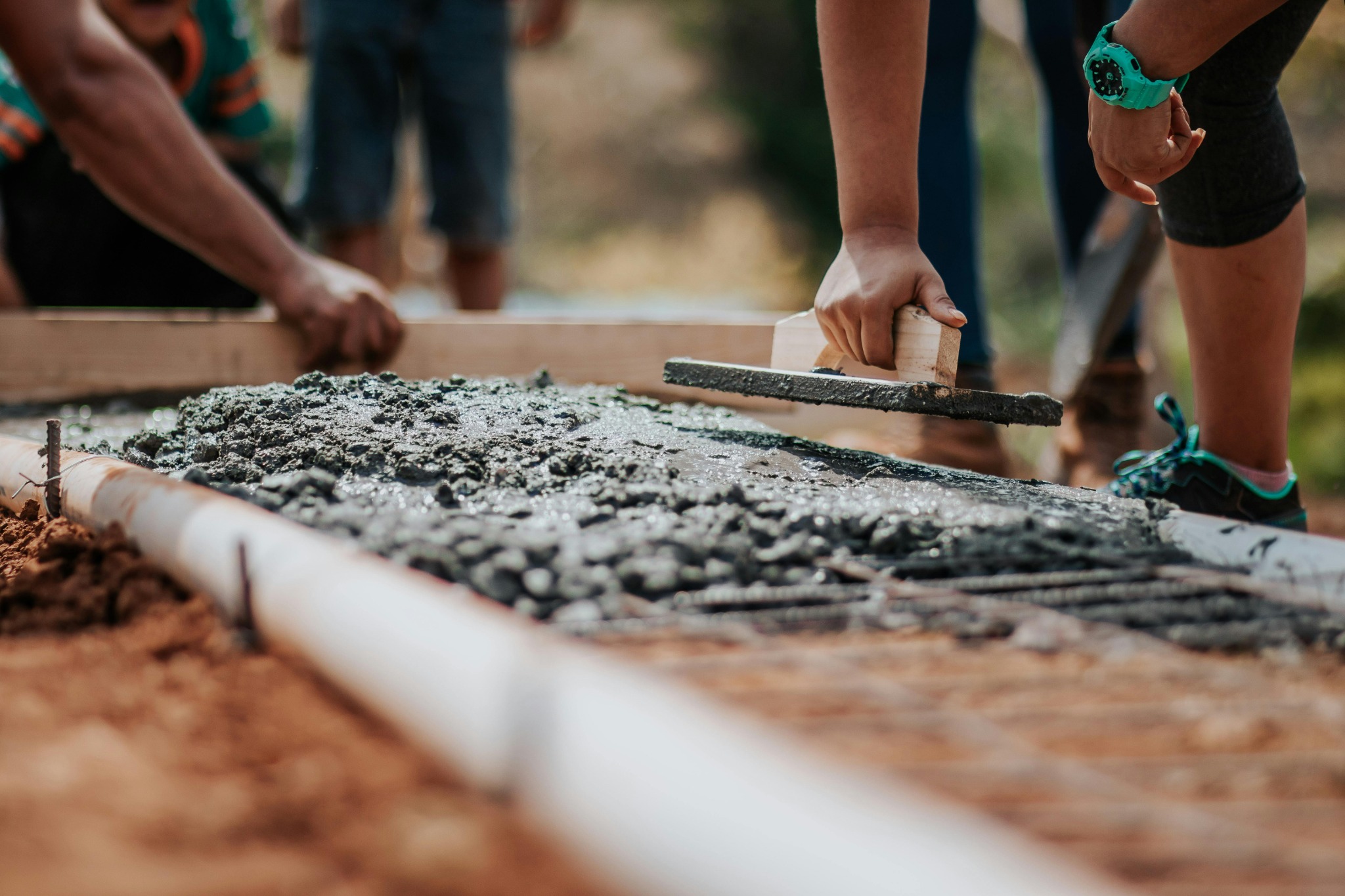 Team levelling freshly poured concrete on a ground slab