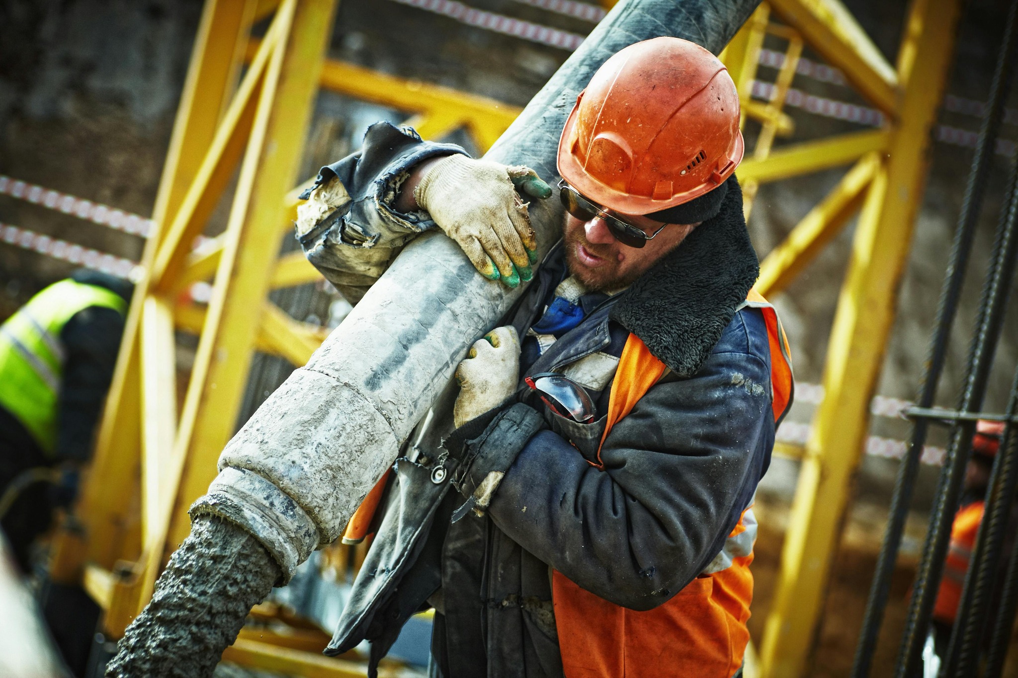 Construction worker handling a concrete pump hose